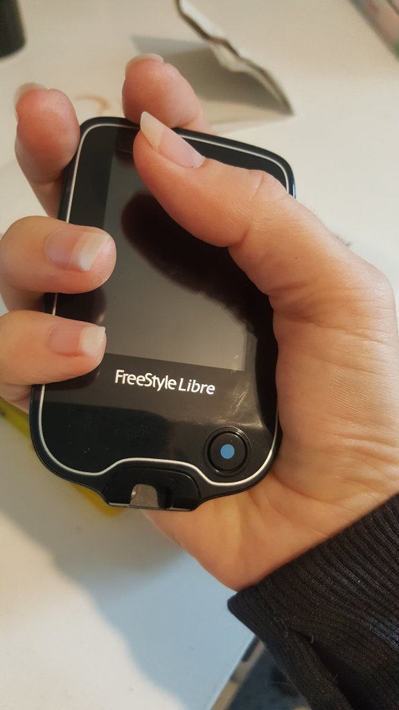 hand holding FreeStyle libre meter